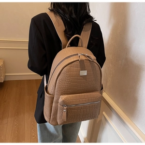 Brown crocodile pattern faux leather backpack showing side view and large capacity
