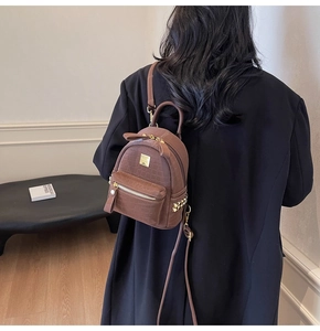 Detailed back view of a brown stone-patterned mini backpack with gold hardware accents