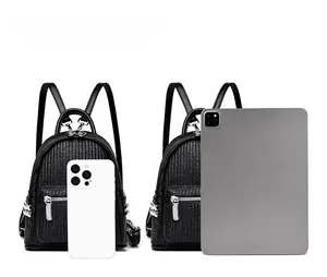 Black fabric mini backpack size comparison with tablet and smartphone devices