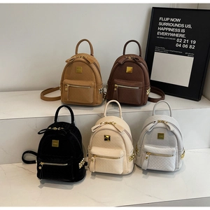 Five assorted colors of mini backpacks with quilted texture displayed on a white podium