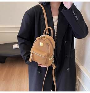 Detail of caramel faux leather mini backpack featuring stone texture and gold hardware