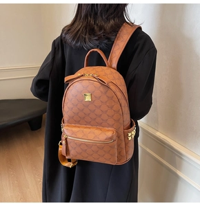 Close-up of stylish brown backpack with vintage logo pattern and golden stud details