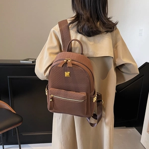 Brown faux leather backpack with woven texture and gold star detail on a female model