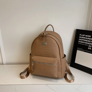 Detail shot of light brown crocodile texture PU leather backpack with gold metal logo