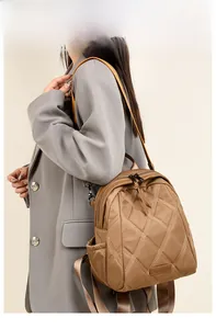Brown quilted nylon backpack featuring large diamond stitching and metallic logo detail