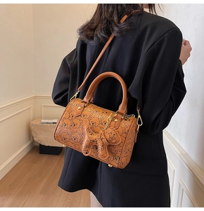 Detail shot of brown barrel bag with bear prints and adjustable shoulder strap