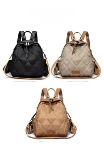 Three-color display of quilted nylon backpacks in black, khaki, and yellow with orange straps