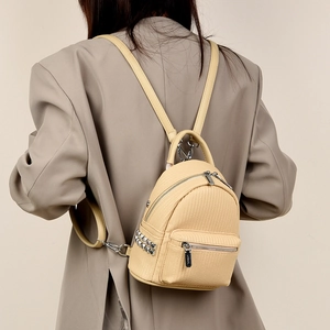 Detail of cream mini backpack side with silver square studs and fine PU leather texture