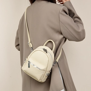 Close-up of woven texture mini backpack with adjustable straps and silver studs