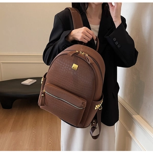 Detail of dark brown stone pattern backpack with gold hardware and side rivets