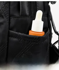 Detail of black quilted nylon backpack featuring an elastic side pocket for cosmetic storage