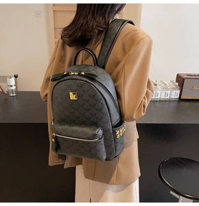 Detail of vintage style backpack featuring golden studs and leather bow tie on the pocket
