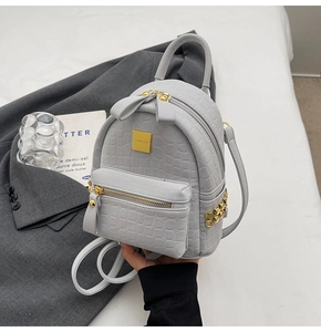 Detailed close-up of stone pattern leather backpack with gold rivets and metallic hardware
