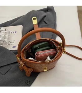 Detail showing the large interior capacity of this brown printed bucket bag with a charm