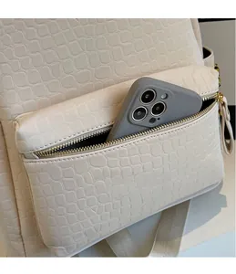 Detail showing high-capacity front zipper pocket on stone pattern backpack with a phone