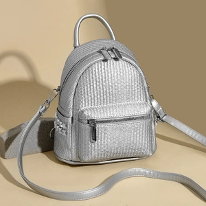 Detail of silver woven mini backpack showing fine texture and stylish side stud accents
