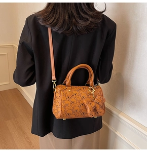 Close-up of the stylish brown bear print barrel bag shown on a model for scale and style