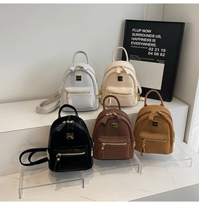 Detailed view of five mini stone pattern backpacks in grey, white, black, and brown
