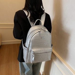Silver crocodile-embossed soft leather backpack shown from behind on a model