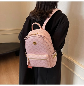 Pink mini backpack with monogram pattern and gold metal hardware shown on model back
