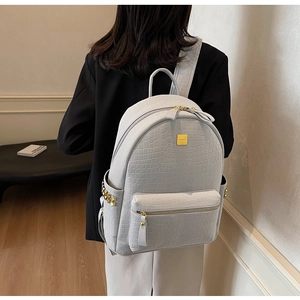 Detail showing high-quality light blue crocodile embossed texture on luxury commuter backpack