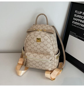 Detailed close-up of MUGK monogram print backpack with gold zipper and side rivet studs