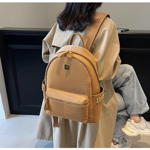Detailed view of the brown stone texture backpack featuring decorative gold rivets