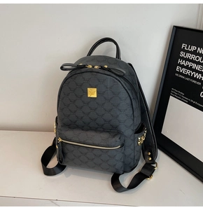 Macro shot of dark grey monogram backpack with gold zippers and metal stud detailing