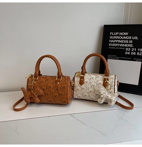 Detail of mini barrel bags with bear prints in brown and cream, including bear pendants