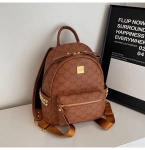 Detailed view of brown mini backpack with golden rivets and monogram print design