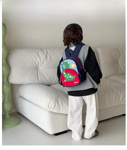 Kid's dinosaur backpack with blue and red color blocking shown on a child model