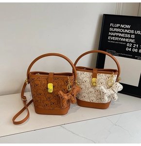Detail view of bucket bags with cute bear prints and a stylish dog-shaped charm pendant