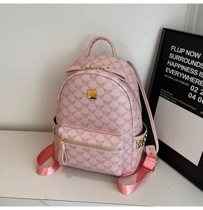 Close-up of pink leather backpack with MUCK monogram print and golden studs details