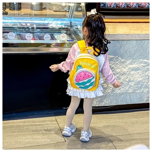 Detail of yellow toddler backpack with dinosaur print and watermelon shaped front pocket