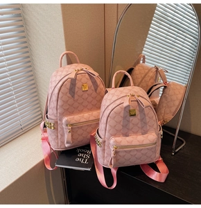 Detailed view of pink monogram backpack with gold studs and brand logo plate
