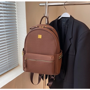 Close-up of brown stone pattern leather backpack with gold rivets and hardware details