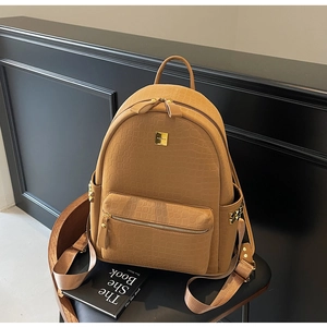 Detail of caramel crocodile pattern backpack with gold hardware and side pockets