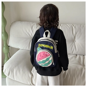 Toddler backpack featuring dinosaur graphics and a 3D watermelon pocket shown on a child