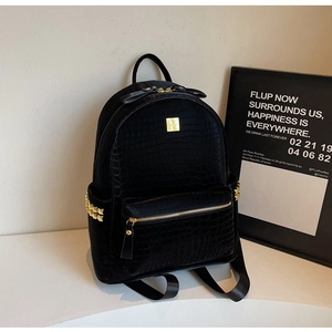 Close-up of black stone-patterned backpack with gold studs and textured faux leather