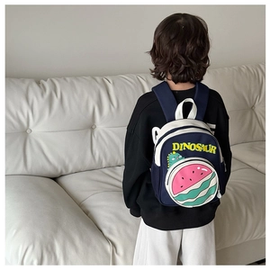 Detail of toddler backpack with dinosaur print and watermelon pocket on a child