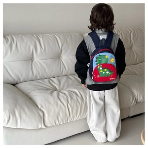 Detail view of colorful dinosaur backpack with padded straps for nursery kids