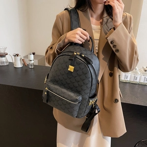 Classic black leather backpack with gold rivets and vintage monogram pattern