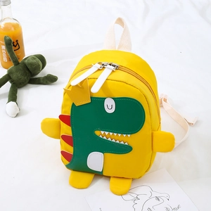 Dettaglio dello zaino giallo per bambini con motivo dinosauro verde e inserti 3D