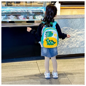 Detail of cute cartoon dinosaur backpack featuring bright contrast colors and mesh pockets