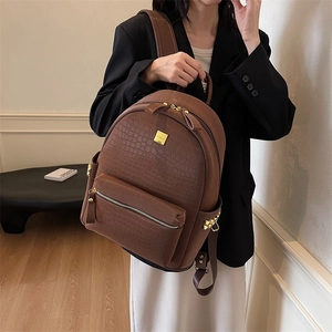 Brown faux crocodile leather backpack with gold zippers and metal logo for women