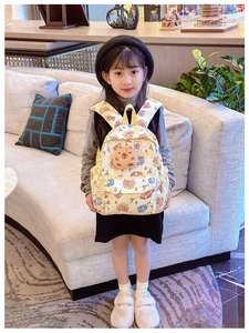Détail de l'imprimé ours et de la tête d'ours en peluche 3D sur le sac à dos beige enfant
