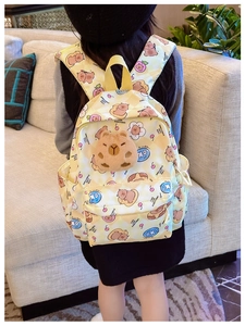 Détail du sac à dos Capybara avec décoration peluche 3D et motif à carreaux jaune enfant