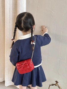 Détail du sac bandoulière rouge matelassé pour fille avec nœud et chaîne dorée