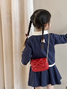 Détail du sac à bandoulière matelassé rouge pour enfant avec nœud et chaîne dorée