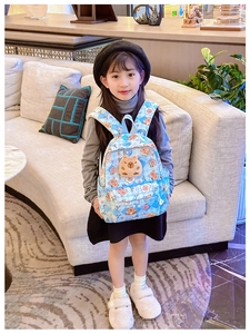Sac à dos enfant à damier bleu avec motif Kapibara présenté dans un cadre d'intérieur